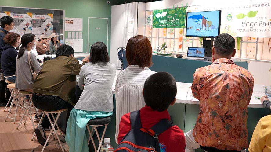 Visitors watching VegeProject's video introducing vegan lifestyles