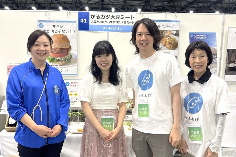 ひょうご食品産業・工業展で大豆ミートを紹介するクッキングオンの代表と社員、主催者のホシザキ阪神の担当者とベジプロジェクトの代表と記念撮影