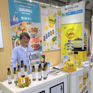 プレミアム・フードショー2025のヴィーガンセレクションで、オリーブオイルやレモン飲料を紹介する株式会社アントレックスのブース