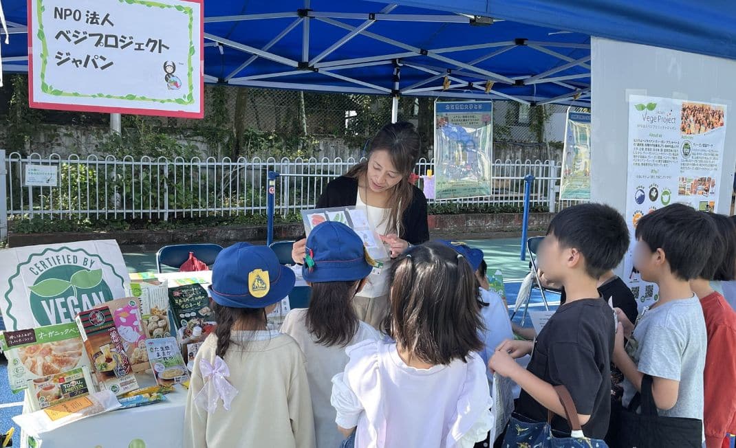 Elementary school students listening to an explanation about veganism at a booth at the Kita City Environmental Exhibition, provided by VegeProject Japan